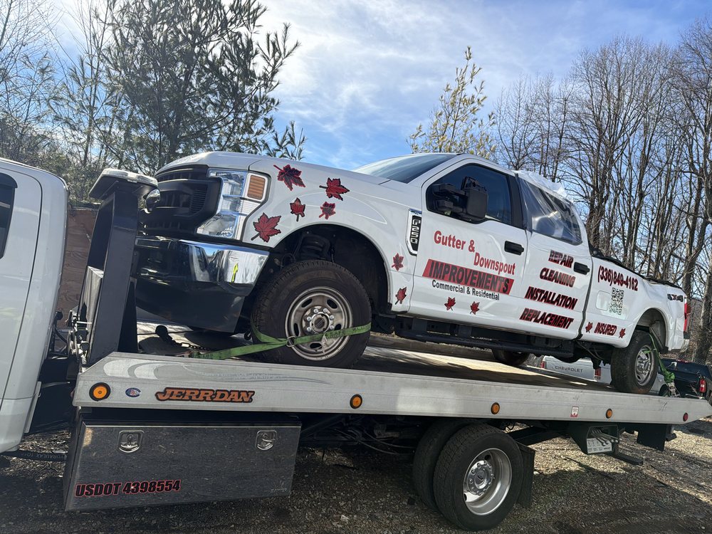 Work truck loaded onto a D&K Jerr-Dan flatbed tow truck