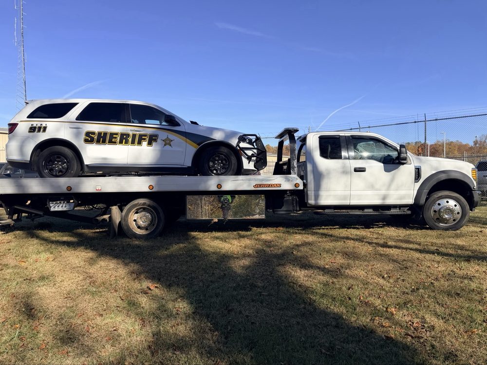 D&K flatbed tow truck hauling a sheriff department SUV